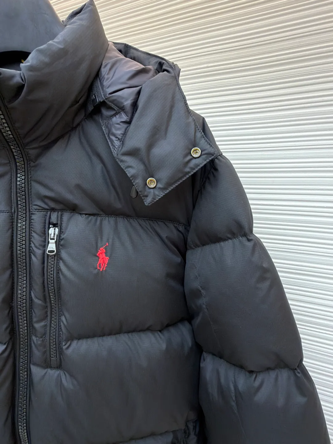 Ralph Lauren classic red label down jacket ●Original version: Purchased and developed in 2099 ●Item number: 1681655-D60 ●Fabric: white duck down fabric ●Technology: mechanical down filling ●Color: black ●Version: fitted version ●Weight: about 835 grams ●Size: S-M-L-XL ●Description: Nylon fabric has good windproof and waterproof properties and can effectively block the intrusion of wind and rain from the outside Keeps the inside dry and suitable for wearing in humid or rainy conditions. The red label on the chest is made with an imported MECLO embroidery machine. The original pattern is scanned first, and then high-quality silk thread is used to make a pattern. The density effect is adjusted by continuous pattern making. Detachable hood: The down jacket is equipped with a detachable nylon hood, which users can easily remove or install according to weather changes or personal preferences, which is both practical and convenient. The details are exquisitely processed: the zipper design is simple and elegant, easy to operate; the closing design of the cuffs and hem effectively prevents the intrusion of cold wind, improving the warmth and comfort of wearing. It uses 90 white duck down with a weight of 260g to ensure excellent thermal insulation performance. After strict screening and processing, the velvet is not easy to drill, ensuring durability. The overall wiring is straight and delicate, the fabric is comfortable and soft, and the color is consistent without color difference. It can be matched with the same style to create a fashionable look and control various occasions. Customized accessories, complete with three standards, same style for men and women!